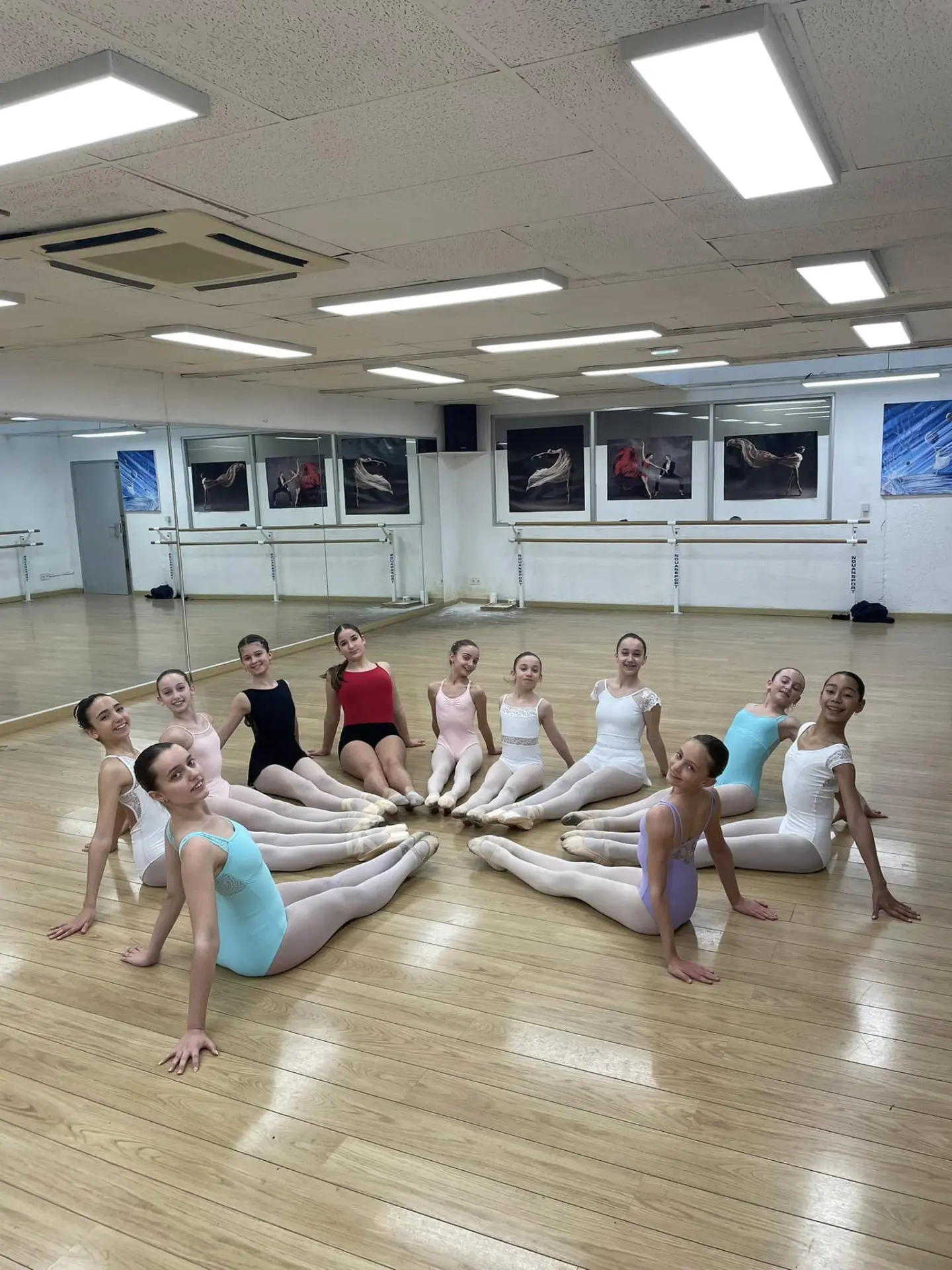 Groupe d'élèves de danse classique assises en studio