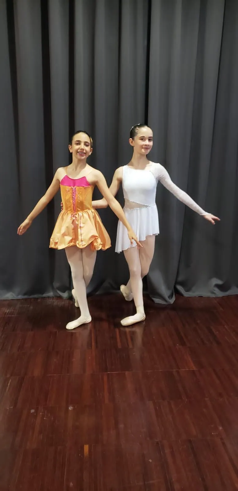 Duo de danseuses classiques en costume orange et blanc sur scène