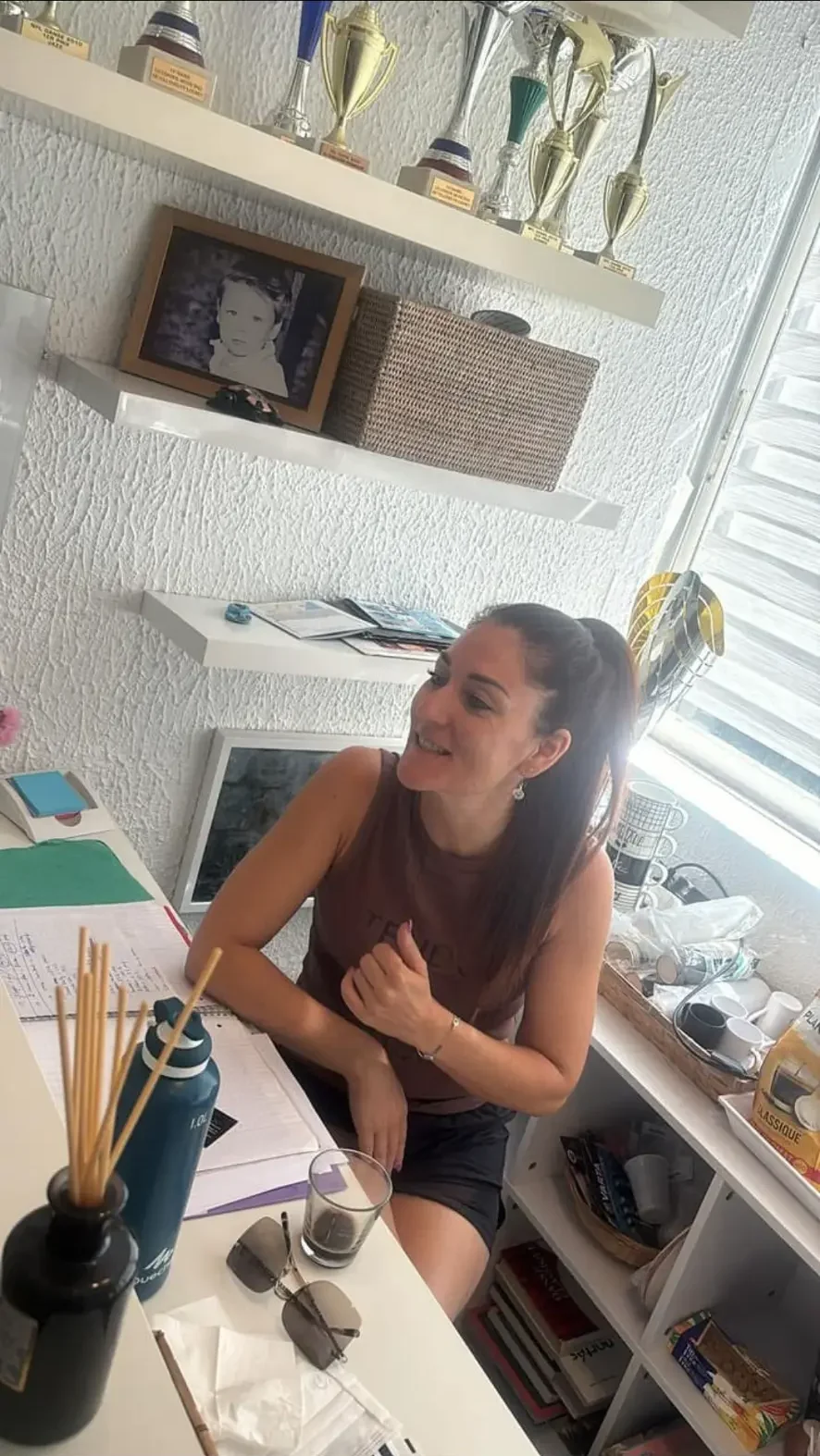 Vanessa Tognetti dans le bureau de l'école devant les trophées