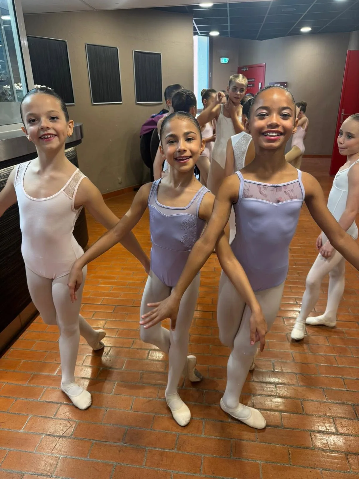 Groupe de jeunes danseuses classiques souriantes dans les coulisses du spectacle