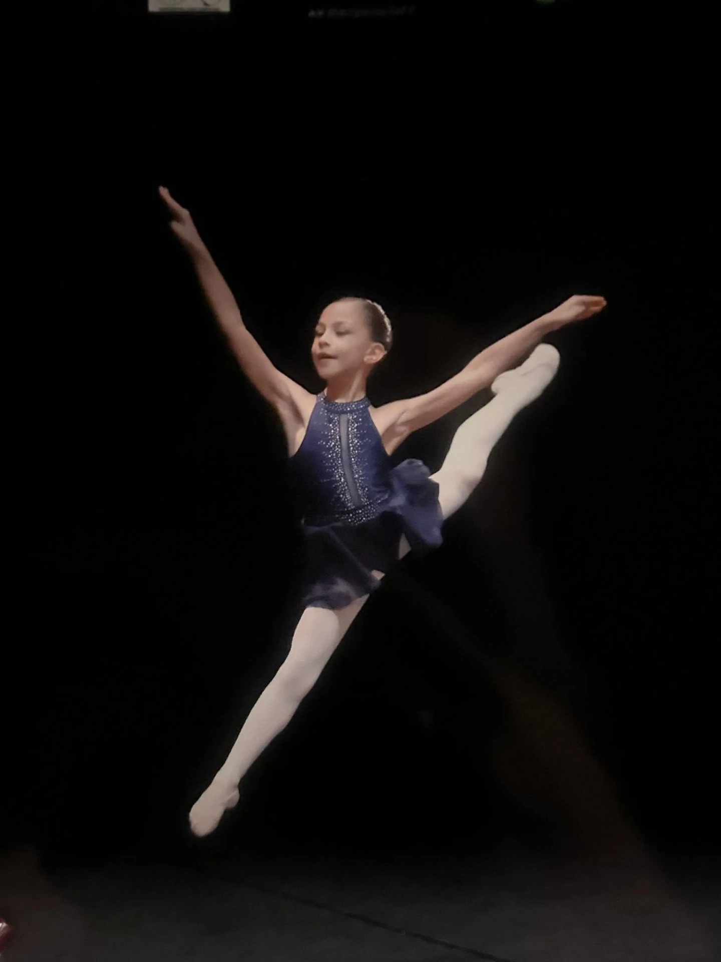 Jeune danseuse en grand jeté sur scène