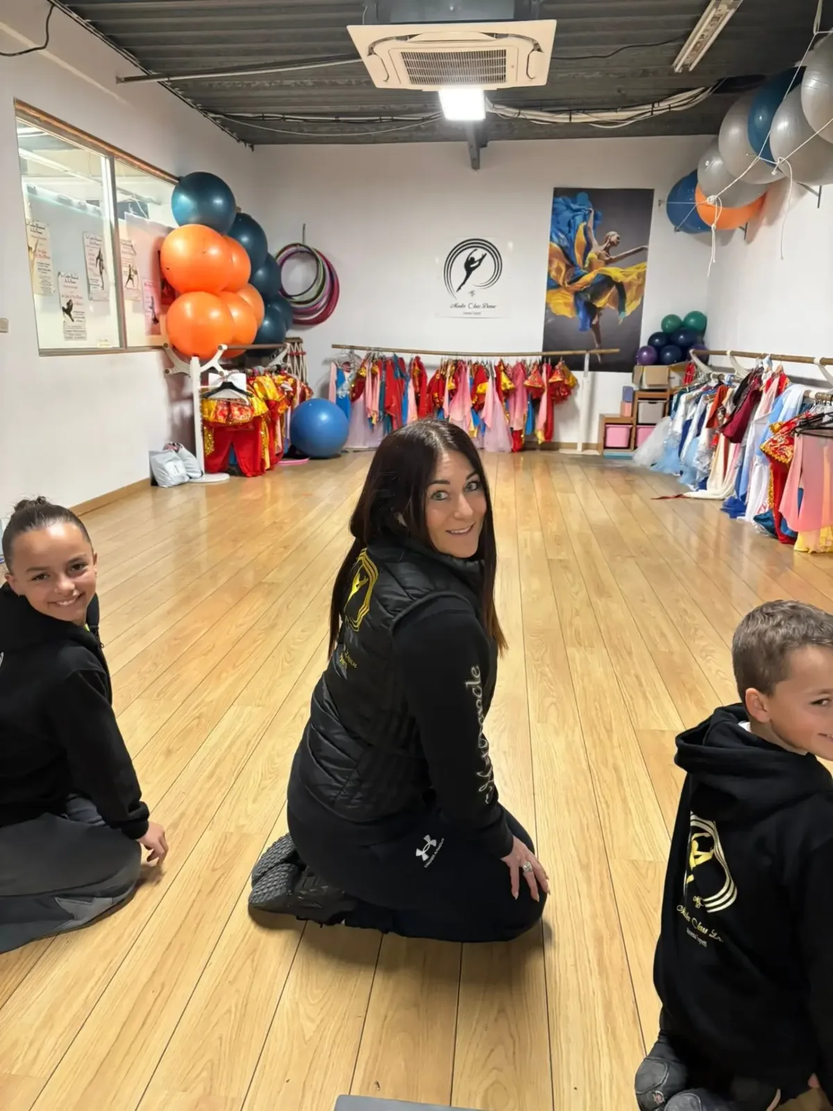 Vanessa Tognetti et de jeunes élèves dans le studio décoré de ballons et de costumes