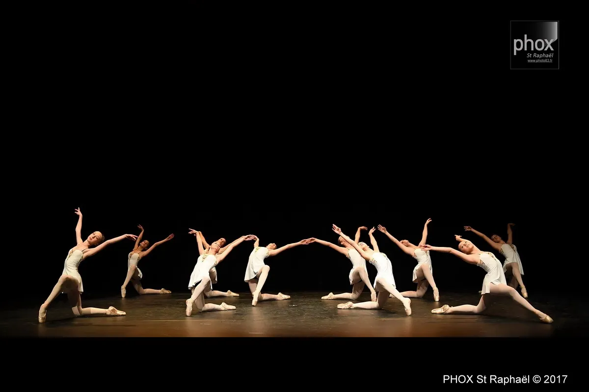 Ensemble de danseuses classiques en tuniques blanches en pose sur scène