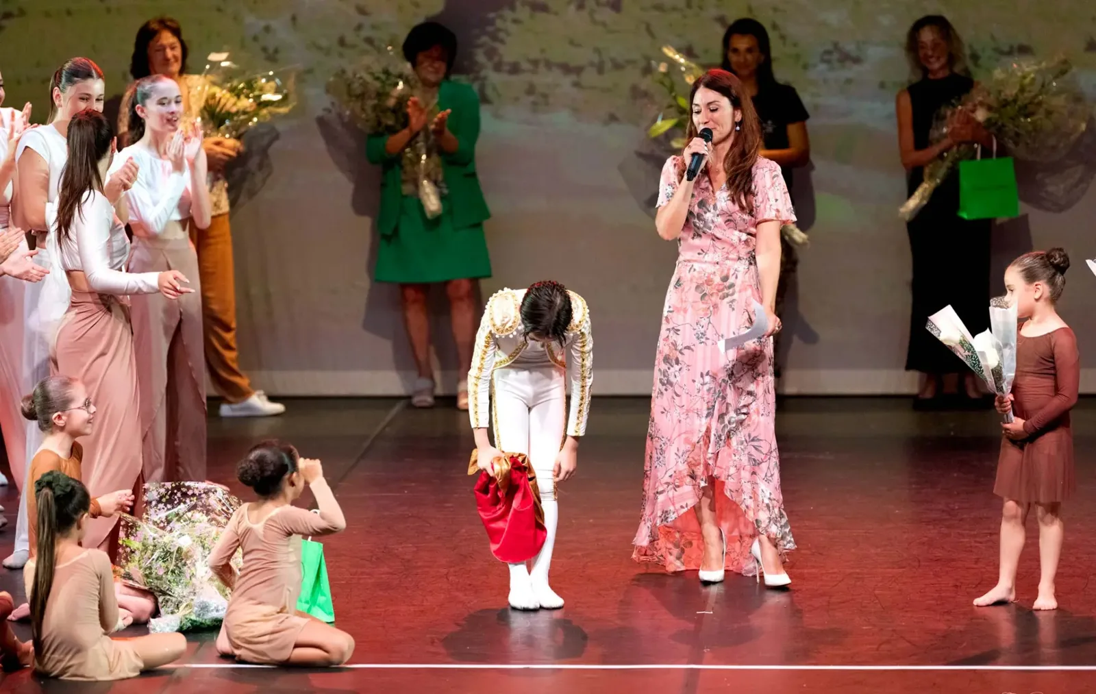 Salut final du gala : Vanessa Tognetti au micro et jeunes danseuses saluant sur scène