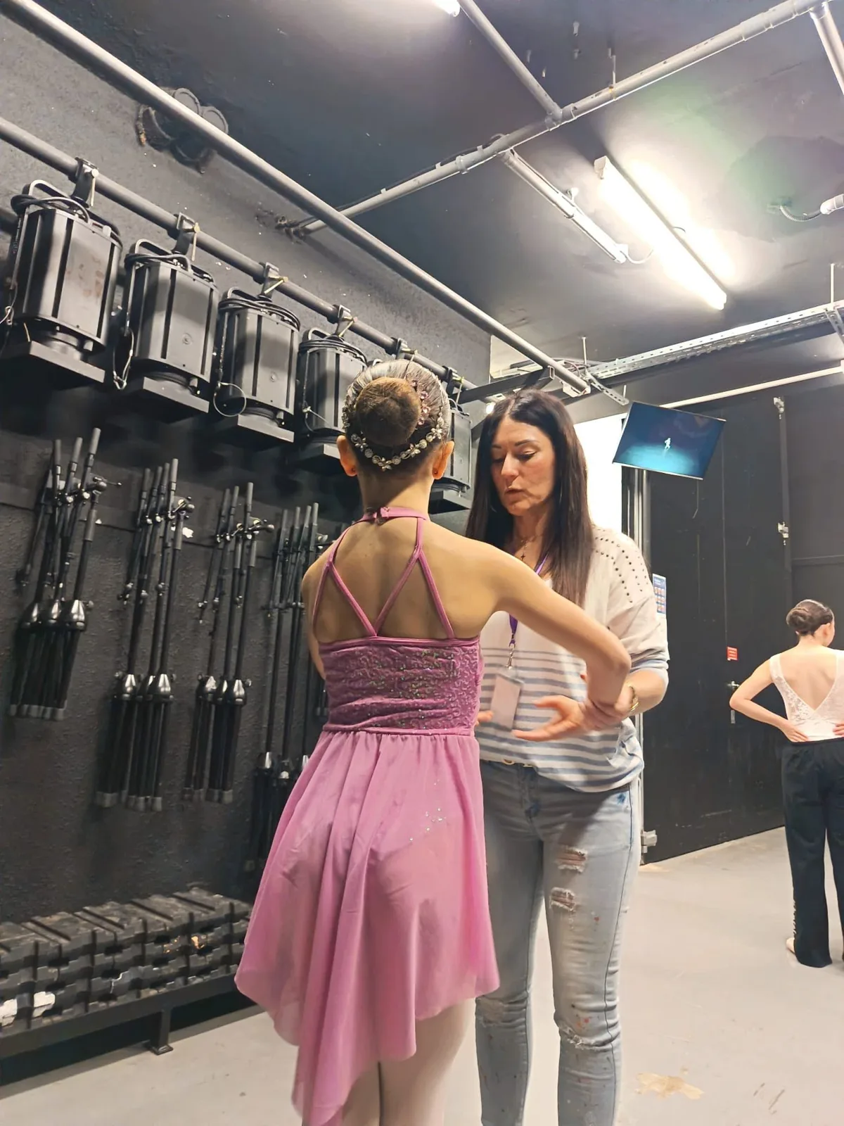 Vanessa Tognetti donnant ses derniers conseils à une danseuse en costume rose dans les coulisses