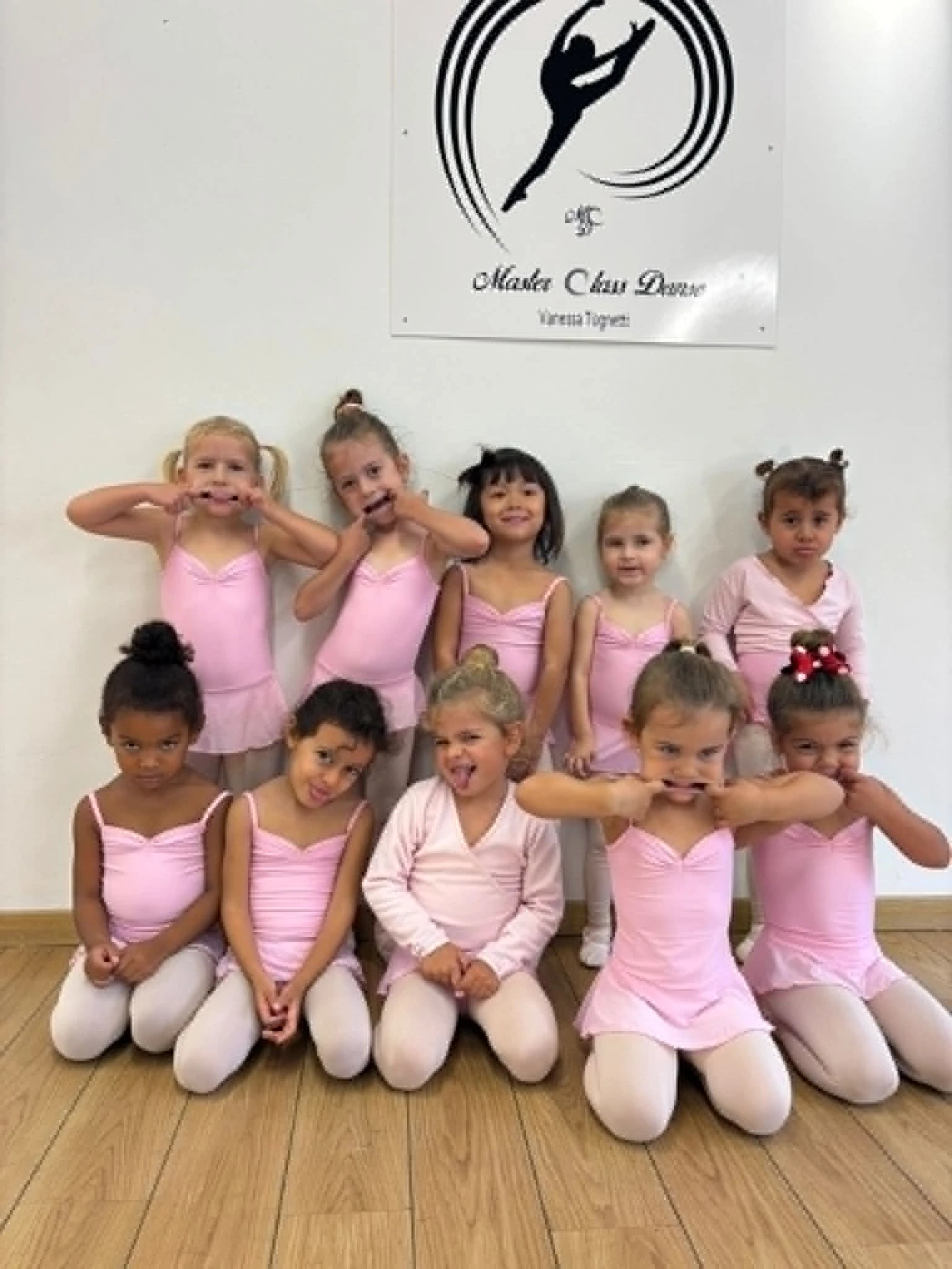Groupe d'élèves d'éveil en justaucorps rose faisant des grimaces sous le logo Master Class Danse